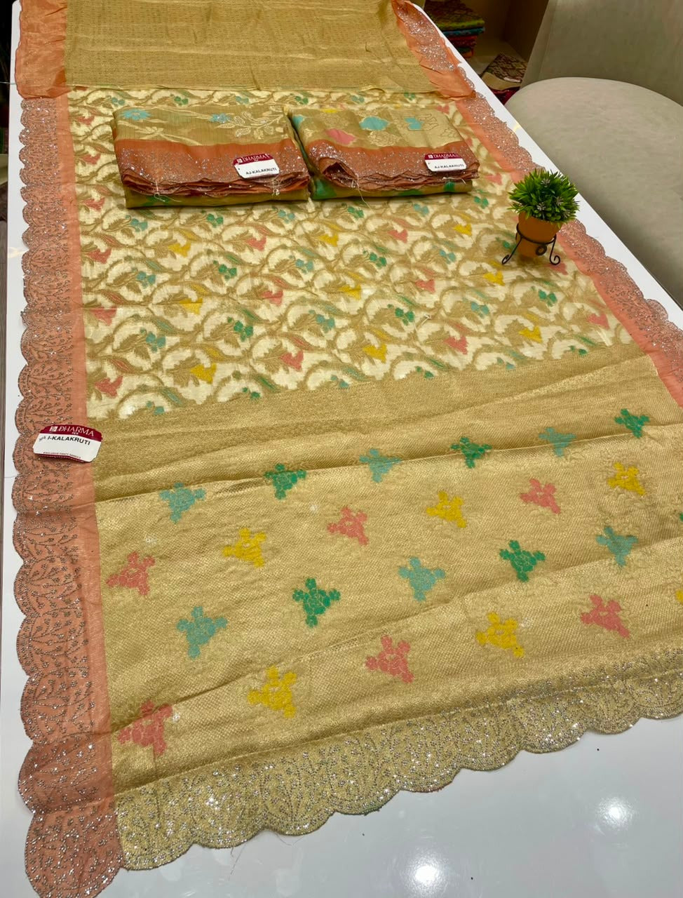 AJ-KALAKRUTI-CATLOGUE A STUNNING FANCY FABRIC SAREE FEATURING RICH MULTI-COLOUR WEAVING, HEAVY SCALLOPED CUTWORK BORDER WITH PREMIUM SIROSKI WORK, AND A BEAUTIFULLY DESIGNED MULTI-COLOUR RICH PALLU, PAIRED WITH A MATCHING BLOUSE PIECE